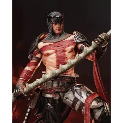 Focus sur la faux : manche osseux, crâne sculpté, lame ensanglantée.