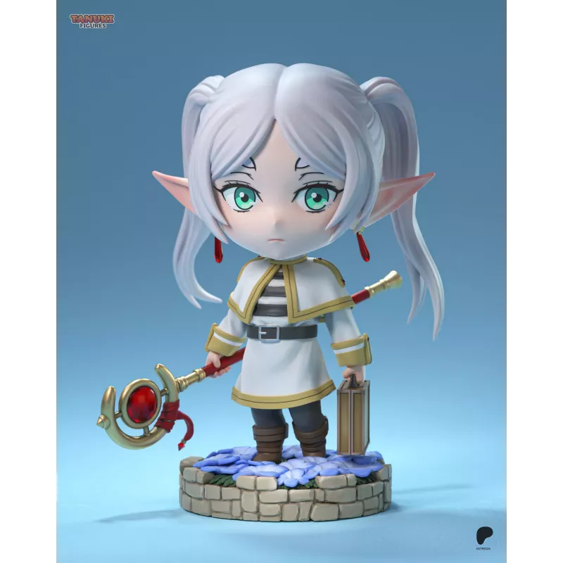 Frieren en version chibi, avec son bâton magique et sa mallette, sur un socle fleuri au rendu délicat.