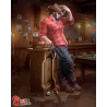 Logan adopte une pose pleine de caractère, vêtu de sa chemise rouge à carreaux, de son pantalon sombre et de ses bottes