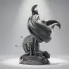 Vue arrière, cape sculptée en plein mouvement, corps de l'ennemi vaincu au pied du socle.