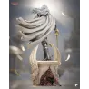 Vue arrière de la statue révélant le mouvement de la cape blanche et l'amas de chair démoniaque s'extirpant du socle.